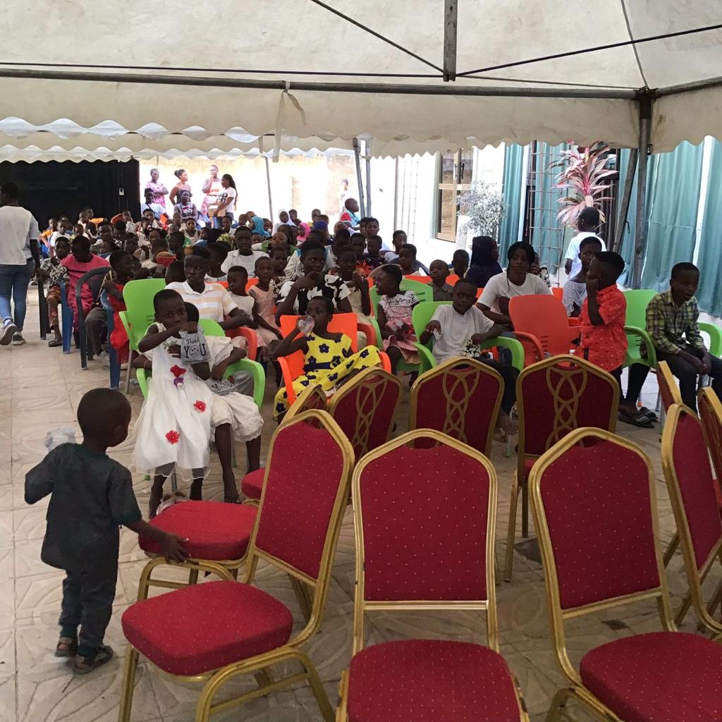 Families at a celebration under a marquee with red chairs