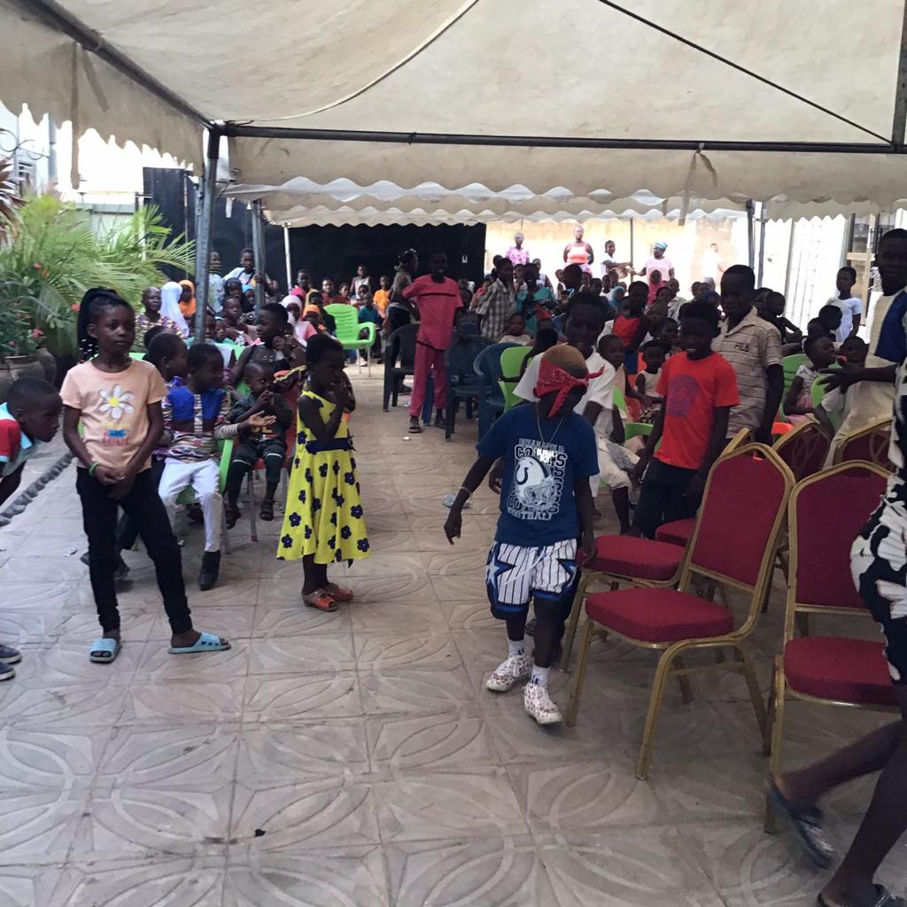 Children and families at a gathering under a large marquee