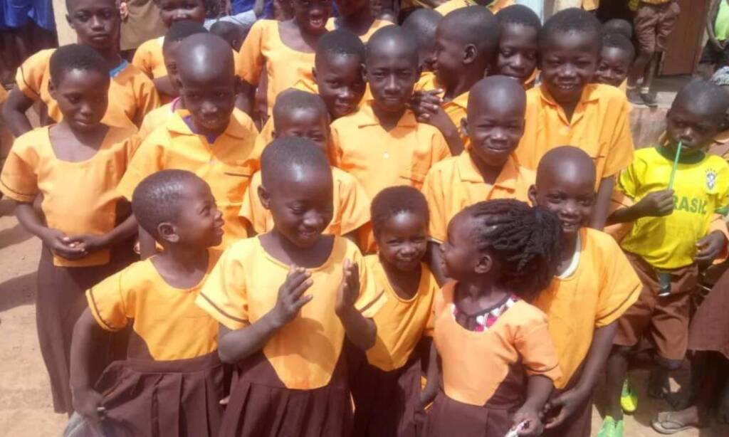 Pupils in yellow and brown school uniforms gathered together in Ghana