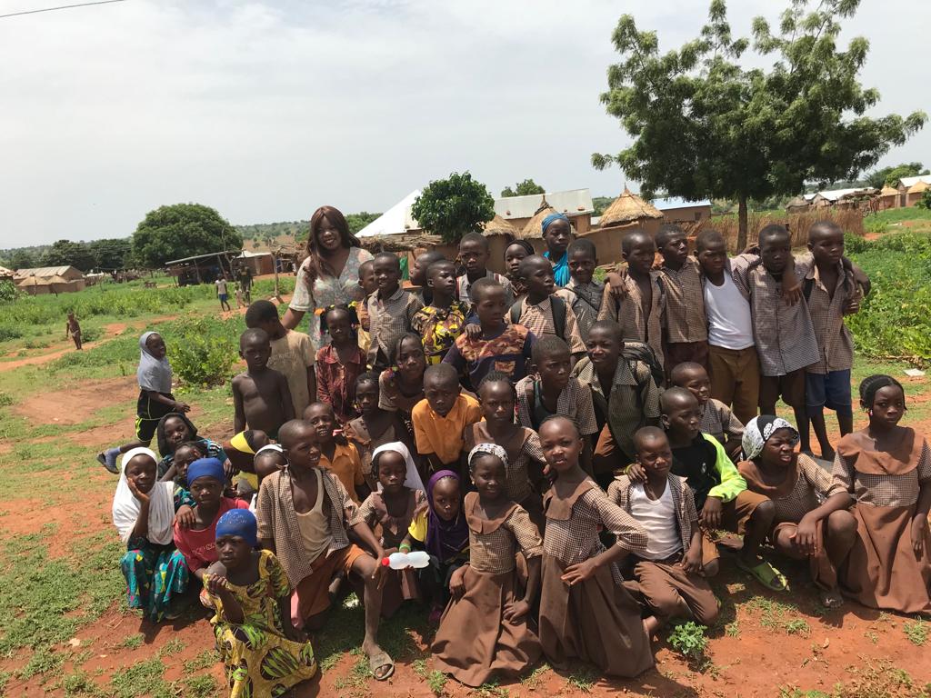 Children and adults from a village community posed together outdoors
