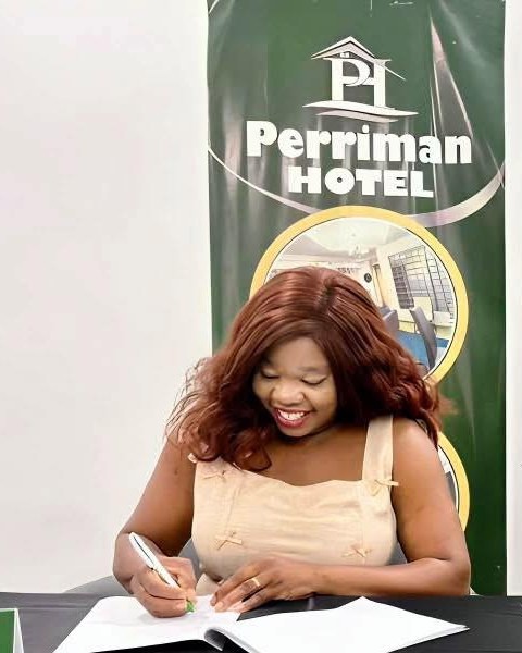 Fatima Perriman signing documents at a Perriman Hotel event
