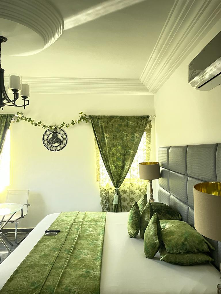 A double room at the Perriman Hotel, with green cushions and a green bed runner